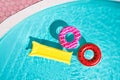 Inflatable rings and mattress floating in swimming pool. Summer vacation Royalty Free Stock Photo