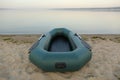 Inflatable rubber fishing boat on sandy beach near river Royalty Free Stock Photo