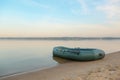 Inflatable rubber fishing boat on sandy beach near river, space for text Royalty Free Stock Photo