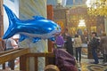 Inflatable shark in the orthodox church. Balloon for children with helium amongst praying people.