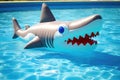 inflatable shark pool toy with sunglasses floating in a pool