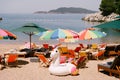 Inflatable white unicorn near sun loungers and umbrellas on the beach near the sea