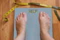 Inflated feet of woman on weighting scale asking for help to lose weight. Diet concept