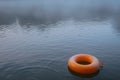 inflated ring bobbing over the surface of a misty morning lake Royalty Free Stock Photo