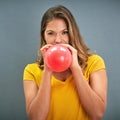 Inflaters gonna inflate. Shot of a young woman inflating a balloon against a gray background. Royalty Free Stock Photo
