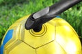 Inflating ball with manual pump outdoors, closeup