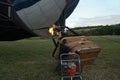 Inflating a balloon lying on the grass with burning air