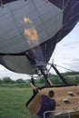 Inflating a balloon lying on the grass with burning air