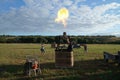 Inflating a balloon lying on the grass with burning air