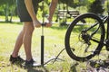 Inflating the tire of a bicycle. Cyclist repairs bike in forest.Inflating the tire of a bicycle. Cyclist repairs bike in forest.