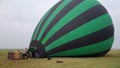 Inflating, unpack and flying up hot air balloon watermelon. Burner directing flame into envelope. Take off aircraft fly Royalty Free Stock Photo