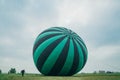 Inflating, unpack and flying up hot air balloon watermelon. Burner directing flame into envelope. Take off aircraft fly Royalty Free Stock Photo