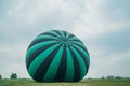 Inflating, unpack and flying up hot air balloon watermelon. Burner directing flame into envelope. Take off aircraft fly Royalty Free Stock Photo
