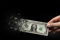 Inflation, dollar hyperinflation with black background. One dollar bill is sprayed in the hand of a man on a black Royalty Free Stock Photo