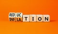 Inflation or reduction symbol. Concept word Inflation Reduction on wooden cubes. Beautiful orange table orange background.