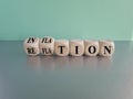 Inflation or reflation symbol.Turned cubes and changes the word inflation to reflation.