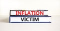 Inflation victim symbol. Concept words Inflation victim on books. Beautiful white table white background. Business inflation