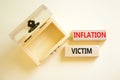 Inflation victim symbol. Concept words Inflation victim on wooden block. Beautiful white table white background. Empthy opened