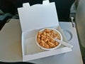 Inflight cereal with milk served on a seat food tray in airplane Royalty Free Stock Photo