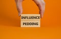 Influence pedding symbol. Wooden blocks with words `Influence pedding` on beautiful orange background. Businessman hand. Busines Royalty Free Stock Photo