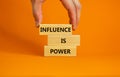 Influence is power symbol. Wooden blocks with words `Influence is power`. Beautiful orange background, businessman hand. Busines