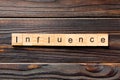 Influence word written on wood block. influence text on table, concept