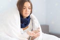 Influenza treatment or coronavirus . Flu-sick woman, wrapped in warm scarf and blanket , taking pills holding glass of water Royalty Free Stock Photo