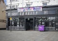 Gravity bar building facade with purple bin in front.