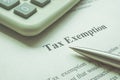 Info about tax exemption with calculator and pen. Royalty Free Stock Photo