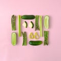 Infographic made of organic asparagus, cucumbers, green paprika and zucchini on a pastel pink background.