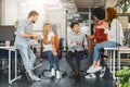 Cheerful millennial team having pleasant conversation in office Royalty Free Stock Photo