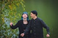 Informal girl with blue hair and a man with pale skin in black clothes at the street walking