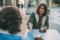 Informal Handshake Between Two Young Male Friends With Long Hair Having a Big Cup of Coffee in a Tab Royalty Free Stock Photo