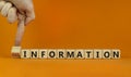 Information or disinformation symbol. Businessman flips a cube and changes the word disinformation to information. Orange