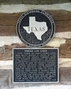 Information plaque for Texas Historic Landmark Torian Log Cabin in the historic district of Grapevine, Texas.