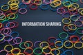 Information sharing concept, colorful rubber band with word Information Sharing on black background