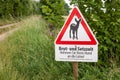 Information sign at the forest in german text means: breed and setteling time. put your dog on a leash. Royalty Free Stock Photo