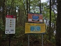 Information signs warning of dangerous rip currents on the beach of Florencia Bay, Vancouver Island in dense forest.