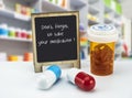 Informational Sign in a pharmacy, do not forget to take your medication, on a whiteboard next to bottles of medicines Royalty Free Stock Photo