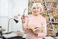 Happy mature woman examining book