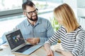 Smiling man giving a presentation to his female colleague