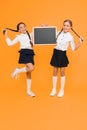 Informing changes. School girls cute pupils hold blackboard copy space. School announcement concept. Classmates
