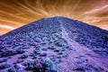 Infrared blue and purple hillside under a reddish cloudy sky