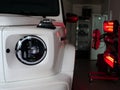 Infrared drying of car body parts after applying putty and paint on a white off-road vehicle in the body repair shop with red lant Royalty Free Stock Photo