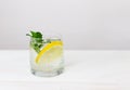 Infused detox and diet water with lemon and leaves of mint on white wooden background with green vegetables Royalty Free Stock Photo