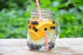 Infused detox water with blueberry, strawberry, orange and mint. Ice cold summer cocktail or lemonade in glass mason jar against a Royalty Free Stock Photo