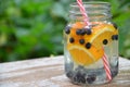 Infused detox water with blueberry, strawberry, orange and mint. Ice cold summer cocktail or lemonade in glass mason jar against a Royalty Free Stock Photo