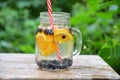 Infused detox water with blueberry, strawberry, orange and mint. Ice cold summer cocktail or lemonade in glass mason jar against a Royalty Free Stock Photo