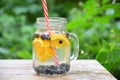 Infused detox water with blueberry, strawberry, orange and mint. Ice cold summer cocktail or lemonade in glass mason jar against a Royalty Free Stock Photo