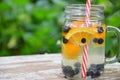 Infused detox water with blueberry, strawberry, orange and mint. Ice cold summer cocktail or lemonade in glass mason jar Royalty Free Stock Photo